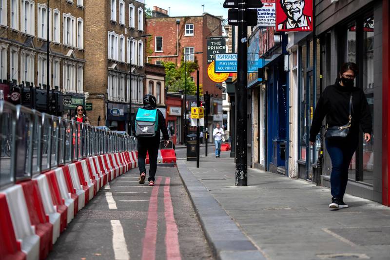 LONDON, ENGLAND  - 17 MAY: A Deliveroo driver walks within a temporary expanded pavement in Earls Court designed to help with social distancing in public on May 17, 2020 in London, United Kingdom. The prime minister announced the general contours of a phased exit from the current lockdown, adopted nearly two months ago in an effort curb the spread of Covid-19. (Photo by Chris J Ratcliffe/Getty Images)