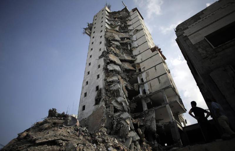 Palestinians inspect the damage to the Italian Complex following several late night Israeli airstrikes in Gaza City, on August 26, 2014. Israel bombed two Gaza City high-rises with dozens of homes and shops on Tuesday, collapsing the 15-storey Basha Tower and severely damaging the Italian Complex in a further escalation in seven weeks of cross-border fighting with Hamas. Khalil Hamra/AP Photo