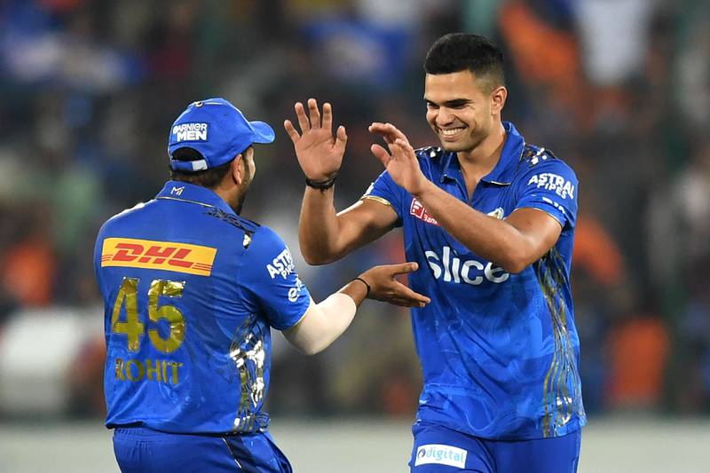 Mumbai Indians' Arjun Tendulkar (R) celebrates with his captain Rohit Sharma after taking the wicket of Sunrisers Hyderabad's Bhuvneshwar Kumar (not pictured) during the Indian Premier League (IPL) Twenty20 cricket match between Sunrisers Hyderabad and Mumbai Indians at the Rajiv Gandhi International Cricket Stadium in Hyderabad on April 18, 2023.  (Photo by Noah SEELAM  /  AFP)