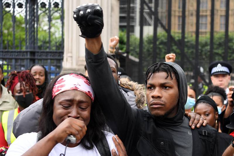 Protestors including British actor John Boyega, centre, raise their fists in Parliament square during an anti-racism demonstration in London.  AFP