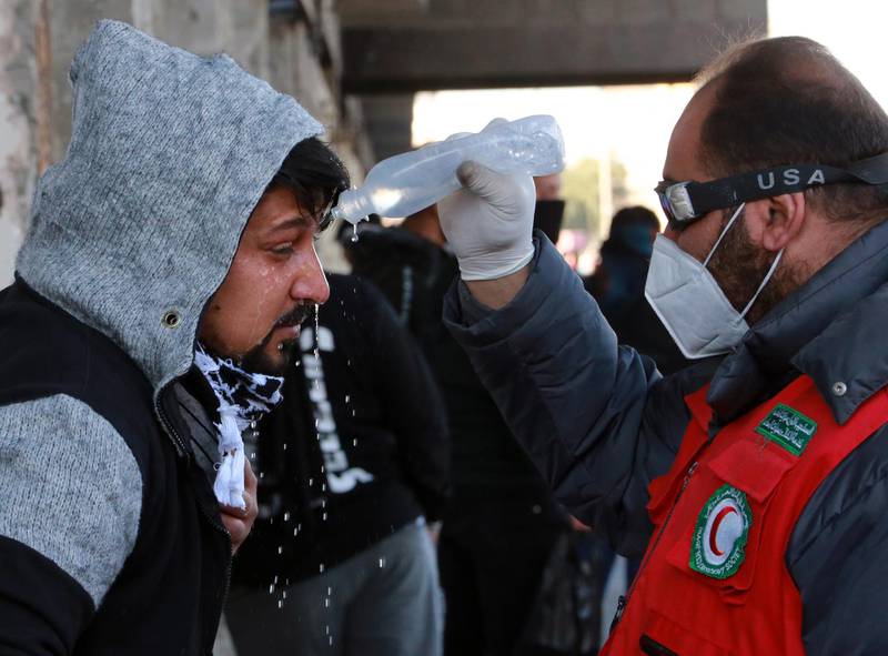 A paramedic helps an Iraqi protester who was affected by tear gas, which was dispensed by riot police during clashes following a protest at the Al-khilani square in central Baghdad.  EPA