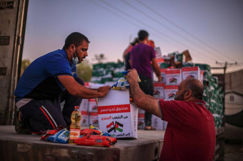 Palestinians unload boxes of Egyptian aid at Rafah border crossing. EPA