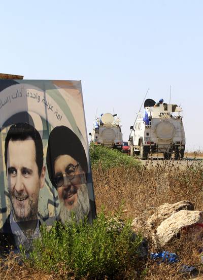 Military vehicles belonging to the United Nations Interim Forces in Lebanon (UNIFIL) drive past posters of the Lebanese Shiiite Hezbollah movement leader Hasan Nasrallah (R) and Syrian President Bashar al-Assad, on a road near the southern Lebanese village of Marjayoun, on August 26, 2019.  Nasrallah yesterday threatened Israel after a "drone attack" on the Lebanese Shiite movement's Beirut stronghold, vowing to "do everything" to thwart future attacks.
Hezbollah, considered a terrorist organisation by Israel and the United States, is a major political actor in Lebanon and a key government backer in war-torn Syria. / AFP / Mahmoud ZAYYAT
