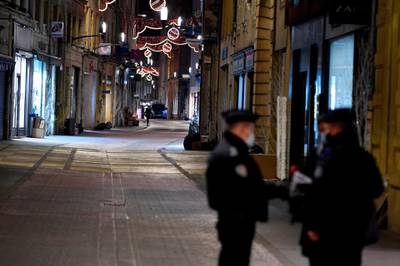 French policemen stand on a deserted street in Metz, eastern France, as a new curfew comes into effect. AFP
