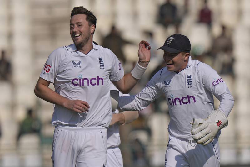 England's Ollie Robinson, left, celebrates with Ollie Pope after taking the wicket of Pakistan's Babar Azam. AP