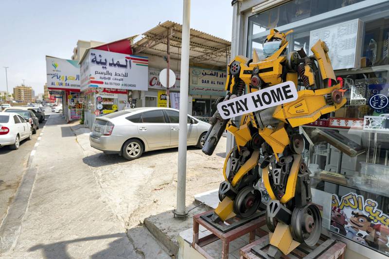 Ras Al Khaimah, United Arab Emirates - Reporter: N/A. Standalone. A model of a transformer robot wears a mask and carries a sign saying 'Stay home' outside a shop in Ras Al Khaimah. Tuesday, August 25th, 2020. Ras Al Khaimah. Chris Whiteoak / The National