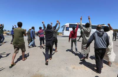 Libyan road transport workers stranded on the Tunisian-Libyan border crossing of Ras Jedir in southeastern Tunisia gesture a farewell as a bus transporting repatriated Tunisian workers takes off. AFP