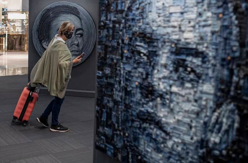 A passenger looks at artworks made by Deniz Sagdic using fabric wastes, on display in the 'O' Zero Point exhibition at Istanbul Airport.