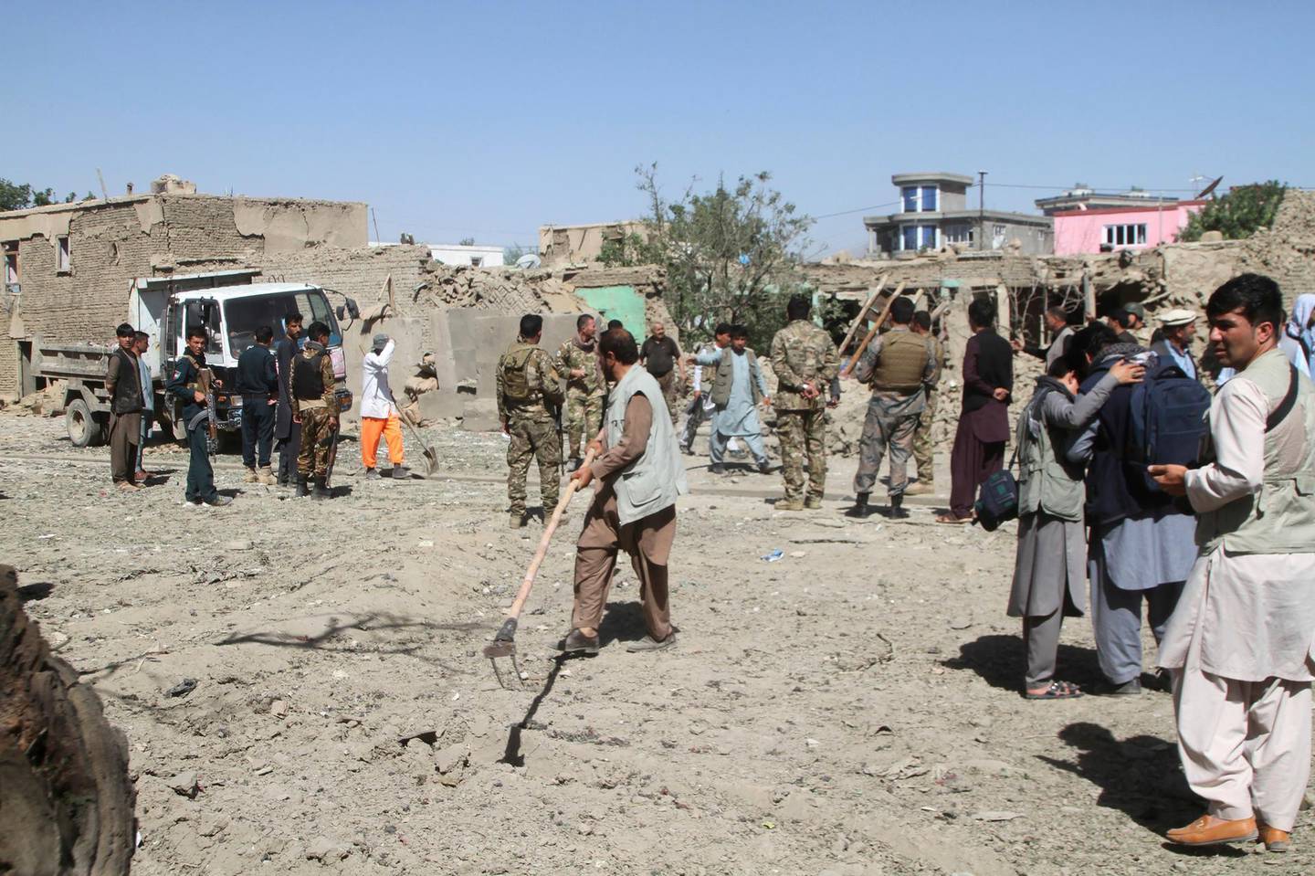 Afghan security forces inspect the site of a car bomb attack in Ghazni province, central Afghanistan, Sunday, July 7, 2019. Afghan officials say a car bomb in central Afghanistan has killed a few people and wounded dozens of people, many of them students attending a nearby school. (AP Photo/Rahmatullah Nikzad)
