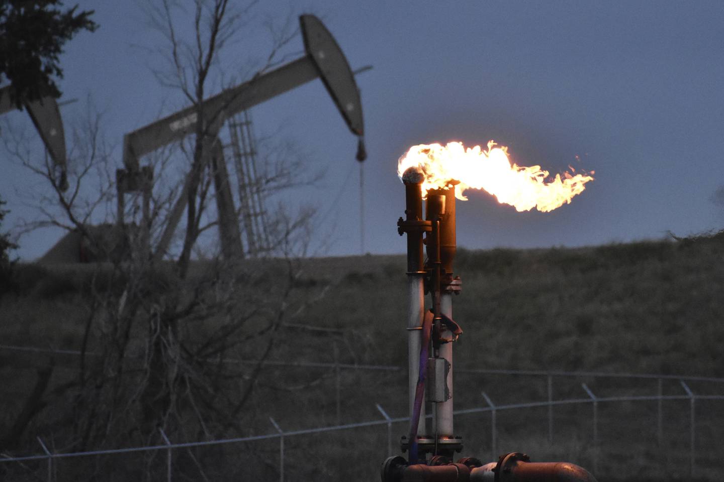 A flare to burn methane from oil production is seen on a well pad near Watford City, North Dakota, in August. AP Photo