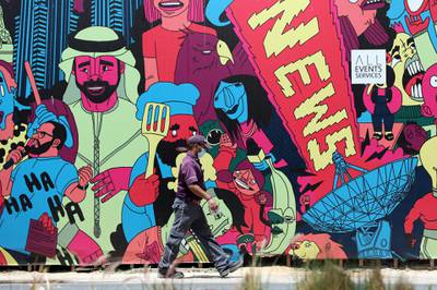 Dubai, United Arab Emirates - Reporter: N/A: Corona. A key worker wears a facemask as he walks passed a brightly coloured mural in Media City. Tuesday, April 14th, 2020. Dubai. Chris Whiteoak / The National