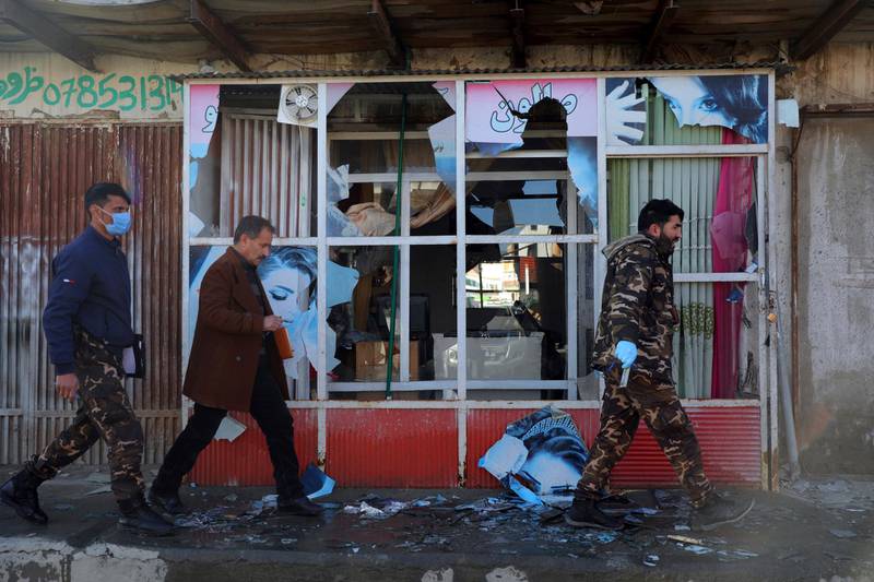 Afghan security personnel inspect a damaged shop after a mortar shell attack in Kabul. AP Photo