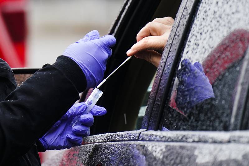 A driver places a swab into a vial at a drive-through test centre in Darby, Pennsylvania. AP