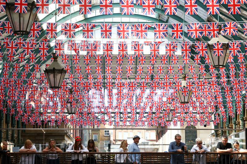People stand underneath Union Jack flags hanging in Covent Garden, London. Reuters