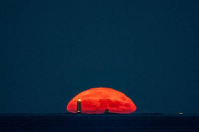The sturgeon supermoon rises over the Graves Lighthouse in Massachusetts Bay, about 15km east of Boston. AFP
