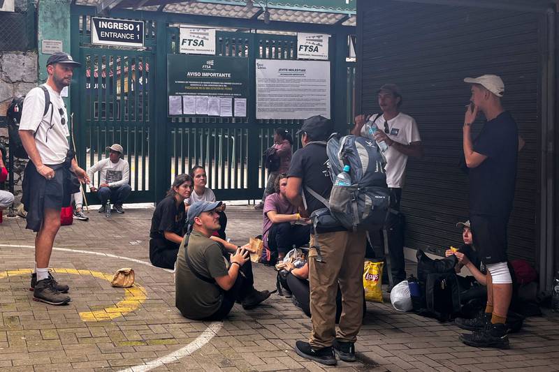 Tourists wait outside the Machu Picchu train station after the railway service was suspended. AFP