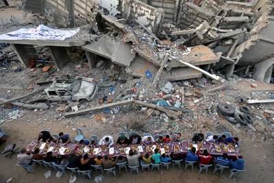 Palestinians break their fast by eating the Iftar meals during the holy month of Ramadan, near the rubble of a building recently destroyed by Israeli air strikes, in Gaza City May 18, 2019. REUTERS/Ibraheem Abu Mustafa       TPX IMAGES OF THE DAY