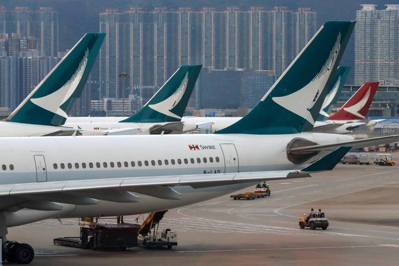 FILE - In this Aug. 12, 2019, file photo, ground crew drive past Cathay Pacific Airways planes park at the Hong Kong International Airport. Hong Kong airline Cathay Pacific says passenger traffic slumped last month on plummeting demand from mainland Chinese travelers. The carrierâ€™s September traffic figures released Friday, Oct. 18, are the latest sign that mainland visitors are staying away from the semiautonomous Chinese city as pro-democracy protests continue.(AP Photo/Vincent Thian, File)