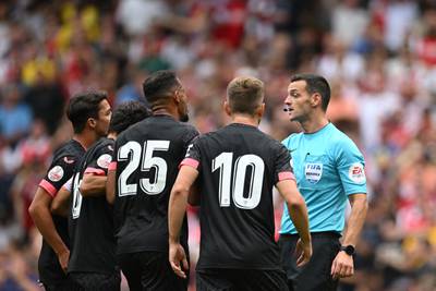 Sevilla's players argue with English referee Andy Madley. AFP
