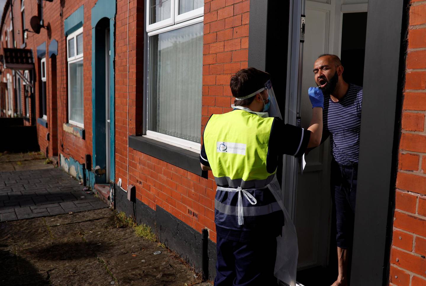 A member of the community swabbing team carries out a doorstep COVID-19 test following the outbreak of the coronavirus disease (COVID-19) in Chadderton, Britain, October 1, 2020. Picture taken October 1, 2020.   To match Special Report HEALTH-CORONAVIRUS/BRITAIN-NEWWAVE  REUTERS/Phil Noble