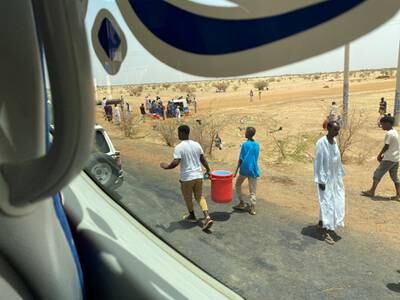 People carry hibiscus juice and cold water for those being evacuated from Khartoum to Port Sudan. Reuters