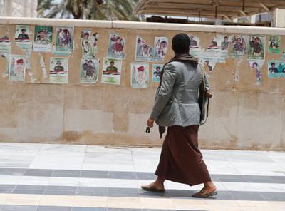 An armed Houthi supporter walks past posters depicting Houthi fighters who were allegedly killed in the Marib offensive, during their funeral outside a mosque in Sana'a. EPA
