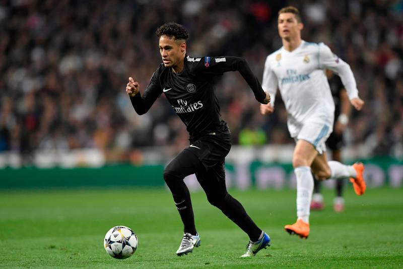 Paris Saint-Germain's Brazilian forward Neymar (L) runs with the ball in front of Real Madrid's Portuguese forward Cristiano Ronaldo (R) during the UEFA Champions League round of sixteen first leg football match Real Madrid CF against Paris Saint-Germain (PSG) at the Santiago Bernabeu stadium in Madrid on February 14, 2018.   / AFP PHOTO / GABRIEL BOUYS
