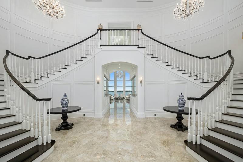 A double staircase leads from the entrance area to the upper floors. Courtesy Sotheby’s International Realty