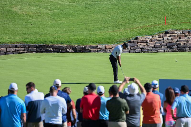 Tiger Woods putts as fans look on during a practice round prior to the start of the 2022 PGA Championship. Getty
