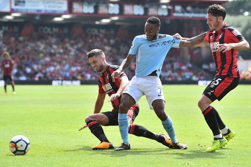 Manchester City's English midfielder Raheem Sterling (C) vies with Bournemouth's South African-born English midfielder Andrew Surman (L) and Bournemouth's English defender Adam Smith (R) during the English Premier League football match between Bournemouth and Manchester City at the Vitality Stadium in Bournemouth, southern England on August 26, 2017. / AFP PHOTO / Glyn KIRK / RESTRICTED TO EDITORIAL USE. No use with unauthorized audio, video, data, fixture lists, club/league logos or 'live' services. Online in-match use limited to 75 images, no video emulation. No use in betting, games or single club/league/player publications.  / 