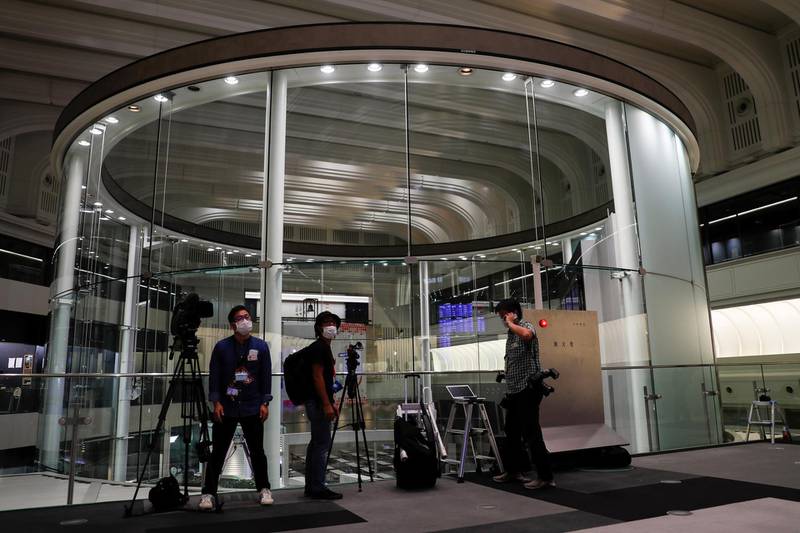 Members of the media are seen working at the empty Tokyo Stock Exchange (TSE) after the TSE temporarily suspended all trading due to system problems in Tokyo, Japan October 1, 2020. REUTERS/Issei Kato