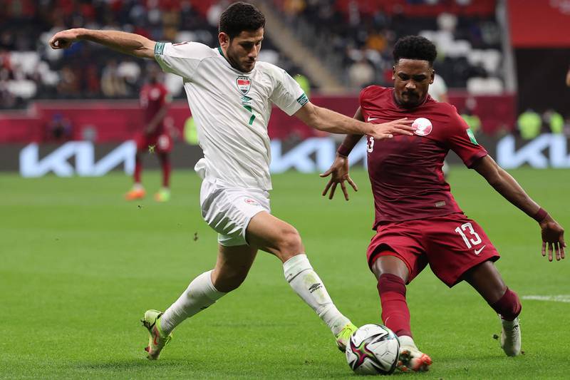 Iraq forward Sherko Karim, left, takes on Qatar defender Musaab Khidir during the Fifa Arab Cup 2021 football match in Al Khor.
