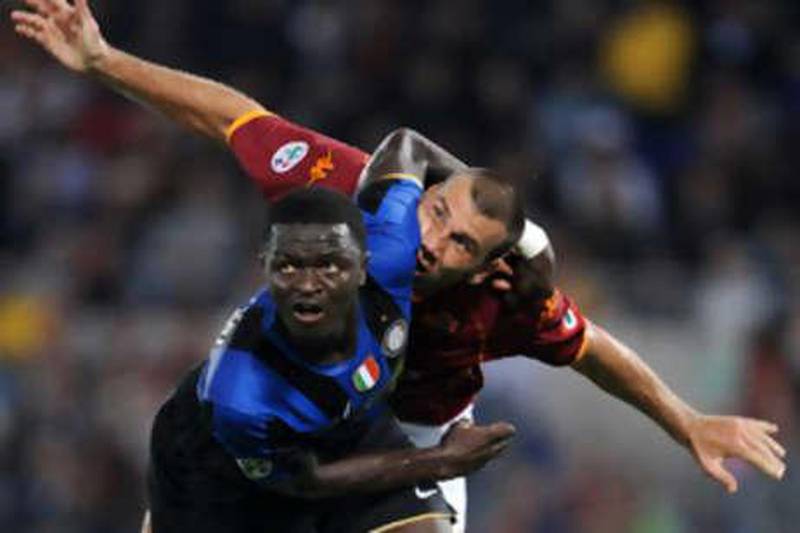 Inter's Sulley Muntari gets the Roma striker Simone Loria in a headlock at the Stadio Olimpico.
