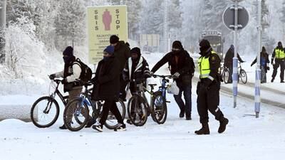Finnish border guards with migrants pushing bicycles at the crossing from Russia, at Salla in Lapland. Reuters  