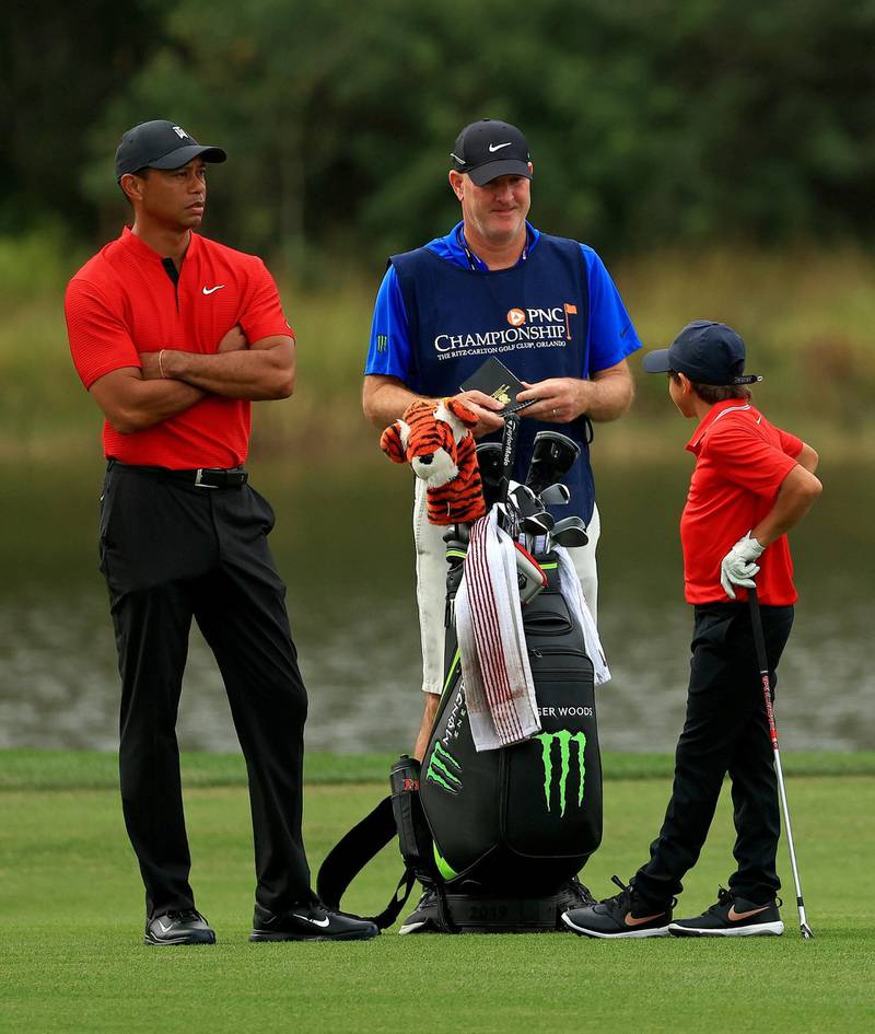 Tiger Woods and son Charlie wait to hit their approach shot with caddie Joe LaCava during the final round of the PNC Championship at the Ritz Carlton Golf Club. AFP