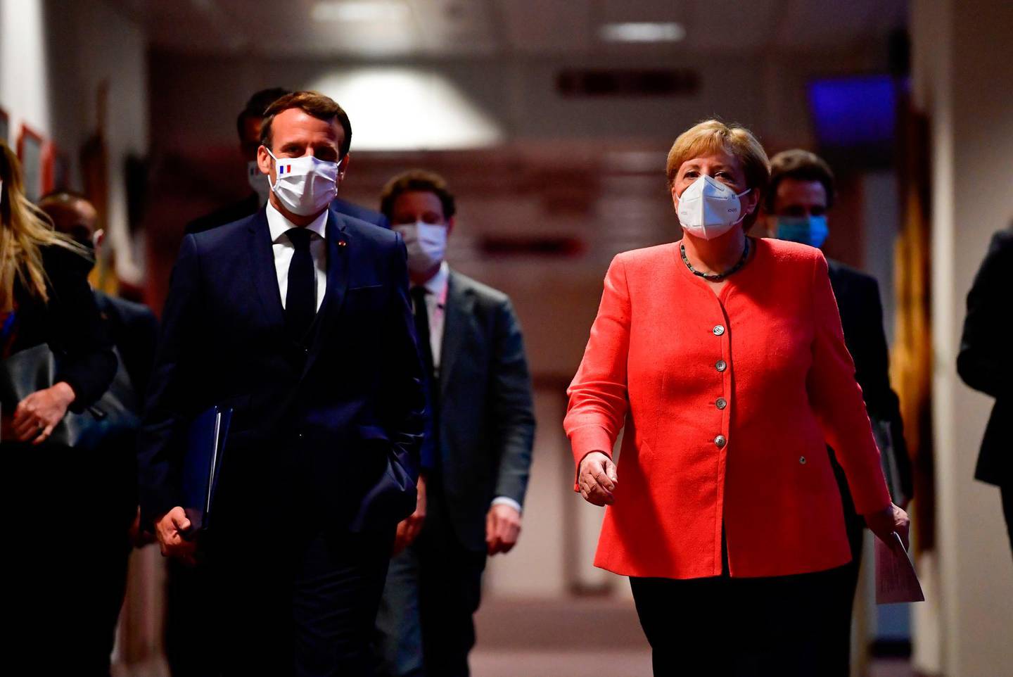 German Chancellor Angela Merkel (R) and French President Emmanuel Macron (L) arrive for a joint press conference at the end of the European summit at the EU headquarters in Brussels on July 21, 2020.  EU leaders approved a 750-billion-euro package to revive their coronavirus-ravaged economies after a tough 90-hour summit on July 21, along with a trillion-euro budget for the next seven years. / AFP / POOL / JOHN THYS
