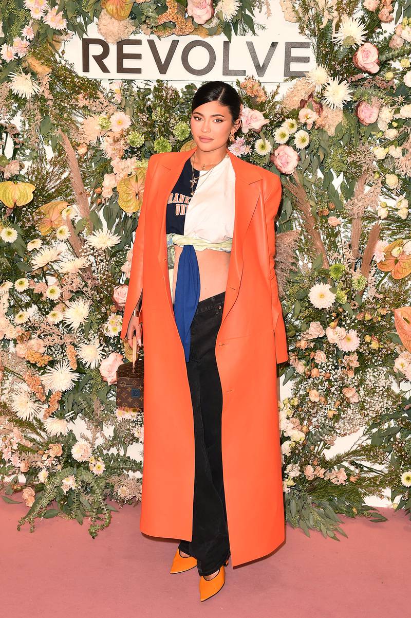 Kylie Jenner, in a crop top and orange 
Off-White trench coat, attends the Revolve Gallery NYFW Presentation And Pop-up at Hudson Yards on September 9, 2021 in New York City. Getty Images