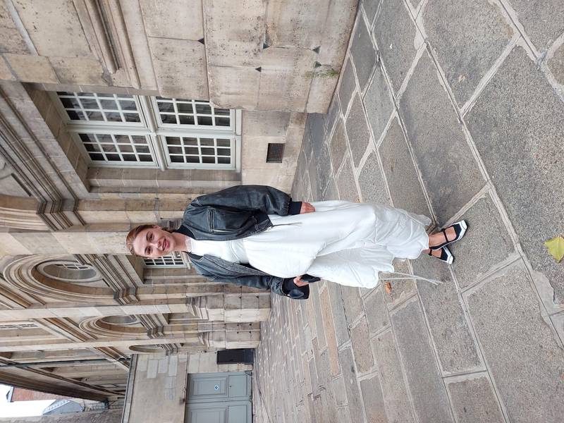 Mixing a cropped bomber jacket with a voluminous dress in Paris.