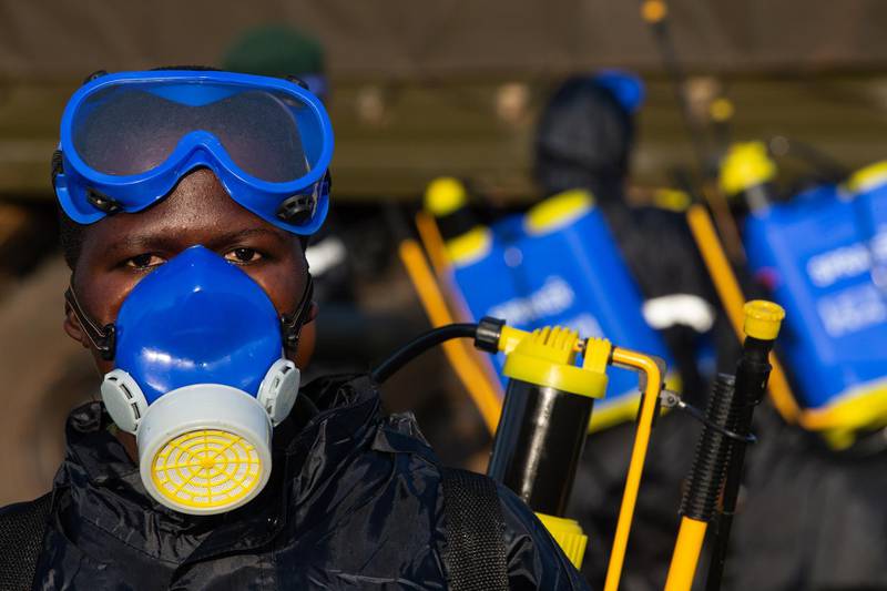 A Uganda People's Defence Force soldier dons protective equipment before spraying crops with pesticide. Getty Images