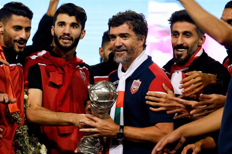 Bahrain's coach Helio Sousa (2nd-R) and team players pose with the trophy during celebrations at Bahrain International Circuit in Sakhir. AFP