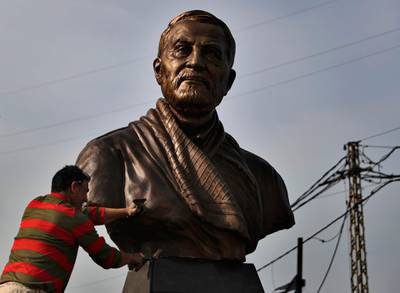 A worker cleans a statue of Iranian general Qassem Soleimani in Ghobeiry, a southern suburb of Beirut, Lebanon. AP Photo
