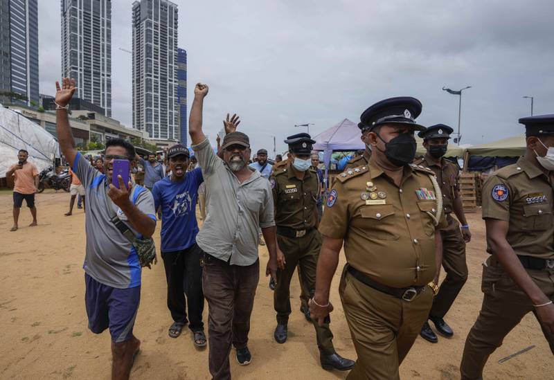 Protesters respond defiantly to a police announcement aired using loudspeakers, ordering them to vacate the site of months-long anti-government rallies outside the president's office in Colombo, Sri Lanka. AP
