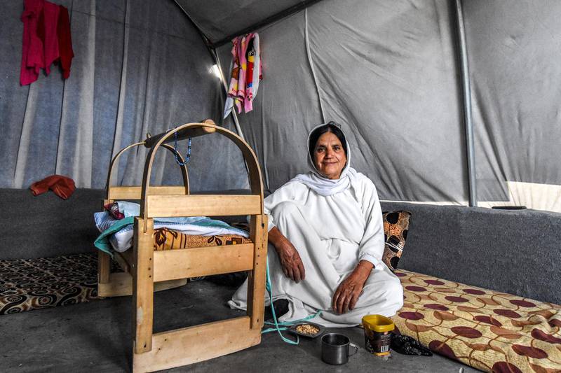 A woman sits on a futon next to a baby cradle inside a tent shelter at a camp for internally displaced persons (IDP) of Iraq's Yazidi minority in the Sharya area, some 15 kilometres from the northern city of Dohuk in the autonomous Iraqi Kurdistan region on August 30, 2019. (Photo by Zaid AL-OBEIDI / AFP)