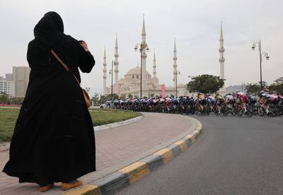 A supporter takes a picture as the pack rides during the fifth stage of the UAE Tour. AFP