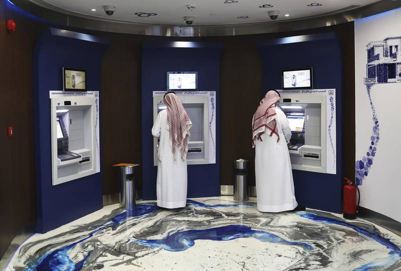 Customers use automated teller machines (ATM) inside the Al Rajhi Bank in Riyadh, Saudi Arabia, on Thursday, Dec. 1, 2016. Saudi Arabia is working to reduce the Middle East’s biggest economy’s reliance on oil, which provides three-quarters of government revenue, as part of a plan for the biggest economic shakeup since the country’s founding. Photographer: Simon Dawson/Bloomberg