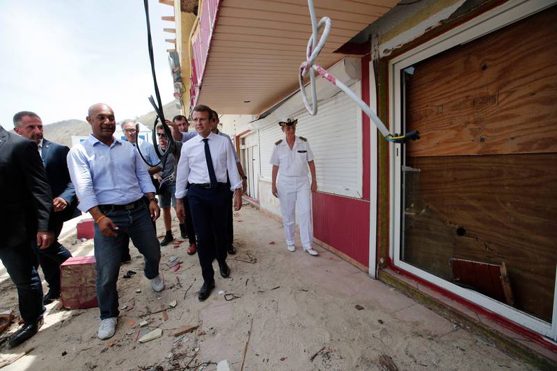 France's President Emmanuel Macron looks at damaged houses destroyed by Irma during his visit in the French Caribbean islands of St. Martin, Tuesday, Sept. 12, 2017. Macron is in the French-Dutch island of St. Martin, where 10 people were killed on the French side and four on the Dutch. (AP Photo/Christophe Ena, Pool)