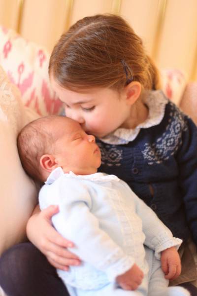 In this May 2, 2018 photograph provided by Kensington Palace, Britain's Princess Charlotte cuddles her brother Prince Louis, on her third birthday, at Kensington Palace, in London. Prince William and his wife Kate have released two pictures documenting the early days of Britainâ€™s newest prince. (Duchess of Cambridge/via AP)