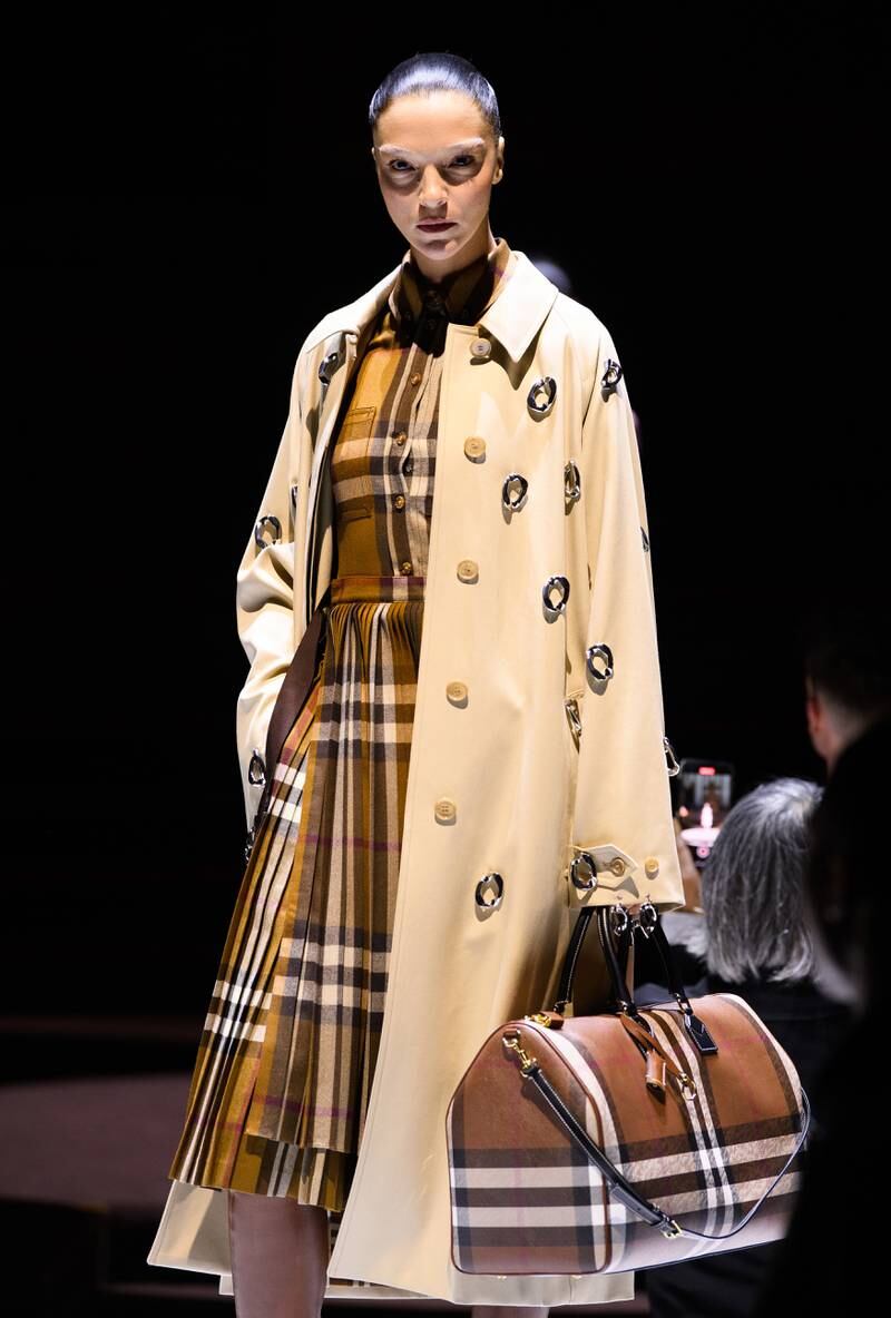Burberry's iconic trench coat was augmented with chains, worn as a dress or printed with trompe l'oeil images.