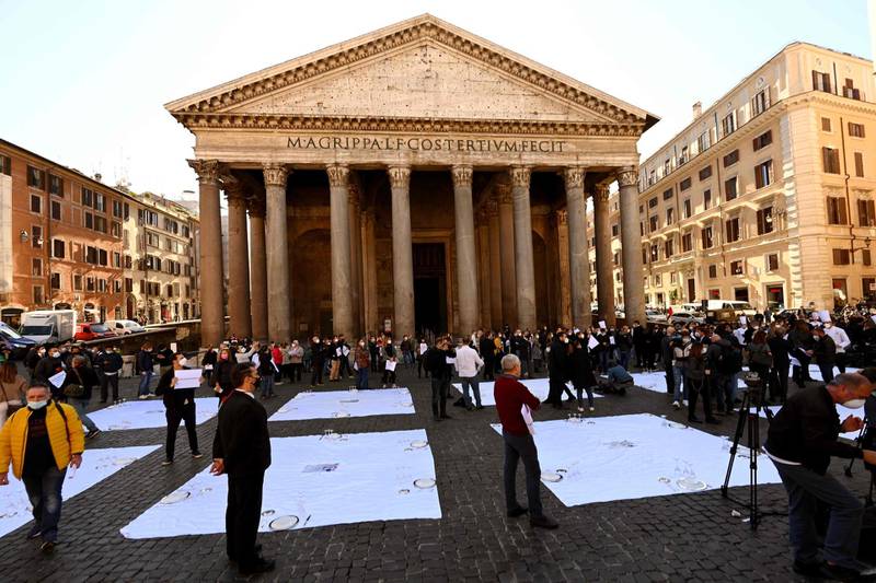 Italian chefs and restaurant owners gather near place settings positioned on the street as they participate in a protest at Pantheon Square in Rome. AFP