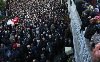 Mourners watch as others carry the Turkish flag-draped coffin of 23-year-old victim Yunus Gormek during his funeral in Istanbul on January 2, 2017. Emrah Gurel/AP Photo